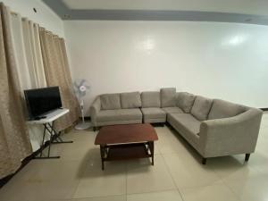 a living room with a couch and a tv at Bulova apartment #3 in Quezon City