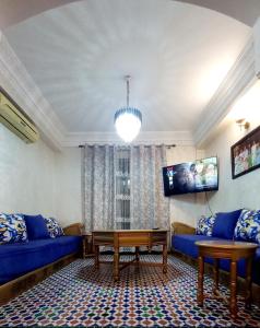 a living room with blue couches and a tv at Charming Oasis in Marrakesh in Marrakech