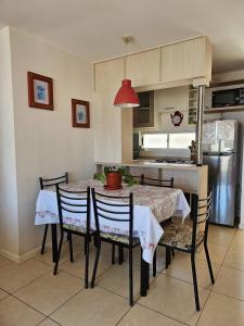 una cucina con tavolo da pranzo, sedie e luce rossa di Bordemar las cruces a San Antonio