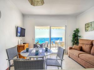 a living room with a couch and a table and chairs at Beachfront Apartment in Platja Almadrava in Montjoys