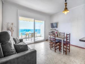 a living room with a couch and a table with chairs at Beachfront Apartment in Platja Almadrava in Montjoys
