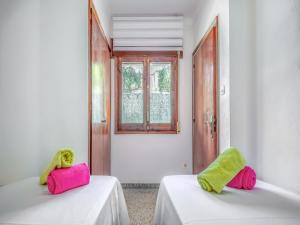 two beds in a room with pink and green towels at Beachfront Apartment in Platja Almadrava in Montjoys