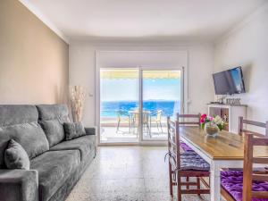 a living room with a couch and a table at Beachfront Apartment in Platja Almadrava in Montjoys