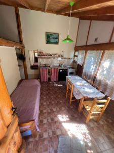 a room with a bed and a table and a kitchen at Cabañas Terraza Sur in El Bolsón +11 photos