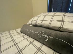 a pillow with the words my new cozy sitting on a bed at Stylish Apartment in Leeds City Centre in Central Station