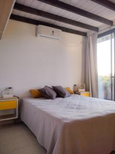 a bedroom with a large white bed and a window at Refugio Verde en Nono, Córdoba in Nono