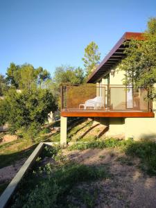 a house with a balcony on the side of it at Refugio Verde en Nono, Córdoba in Nono