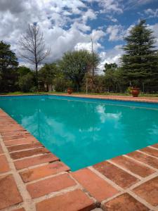 a swimming pool with blue water in a yard at Refugio Verde en Nono, Córdoba in Nono