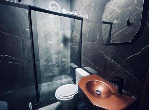 een badkamer met een toilet, een wastafel en een douche bij Meu Loft Barra Nova 2 in Saquarema +3 foto's