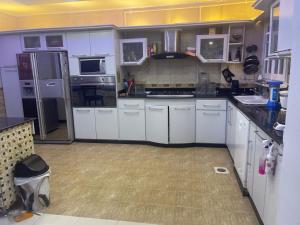 Una cocina con gabinetes blancos y un refrigerador. en Borg Asia building, en Alejandría