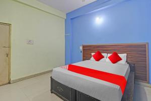 KarīmnagarにあるHotel O Satya Innのベッドルーム1室(大型ベッド1台、赤い枕付)
