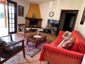 un salon avec un canapé rouge et une télévision dans l'établissement Chácara Verzani, à Socorro