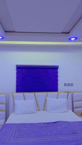 a bedroom with a bed with a blue board above it at Urban Shortlet Abuja in Abuja
