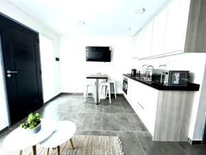 a kitchen with white cabinets and a table and chairs at Departamentos Valdivia Santiago Bueras in Valdivia