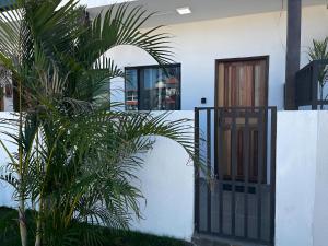 een huis met een hek en palmbomen bij Meu Loft Barra Nova 2 in Saquarema