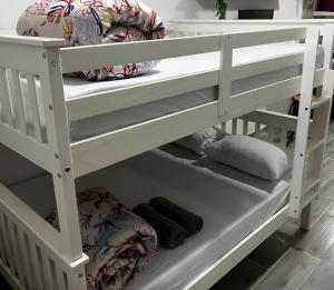 een wit stapelbed met kussens op de onderste plank bij Meu Loft Barra Nova 2 in Saquarema