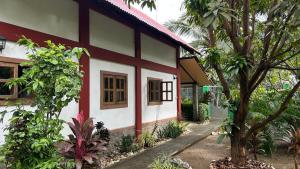 a red and white house with trees in front of it at Strandhaus auf Sibuyan Island nahe Cresta de Gallo - Marevic's Guesthouse 2 in San Fernando