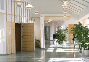 um corredor com vasos de plantas num edifício em Hotelli Joentalo em Tornio