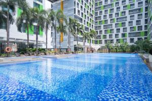 a large swimming pool with palm trees and buildings at APARTMENT AIRPORT TAN SON NHAT - free Pool & Gym in Ho Chi Minh City