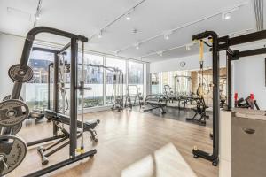 a gym with several treadmills and machines at Modern & Cosy Flat in Kingston in Kingston upon Thames