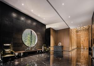 um homem de pé na entrada com um espelho em Wanda Yi Hotel Chengdu em Chengdu