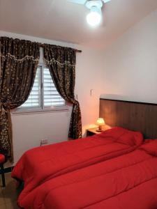 a bedroom with a red bed and a window at La Juana in Juana Koslay 