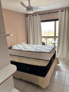 two beds in a room with a balcony at Monte Castelo Flat 08B in Sairé +18 photos