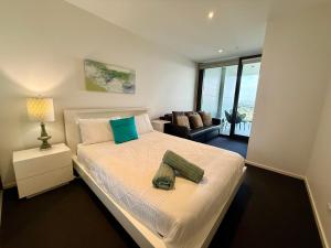 堪培拉Manhattan Luxe Views L14 Pool Spa Gym 1BR 1 Bath 1 Secure Parking Central City的一间卧室，里面有一张床、一把椅子和一扇窗户 更多37张照片