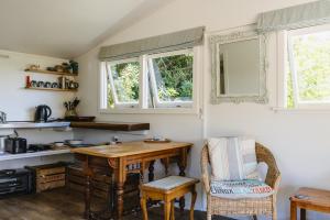 une cuisine avec une table en bois et deux fenêtres dans l'établissement Haumoana Herb Cottage, à Haumoana