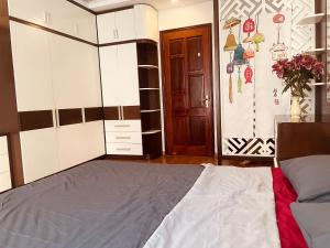 a bedroom with a bed and a cupboard at Laca Home in Hanoi