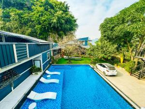 a swimming pool with a car parked next to a house at Ninh Binh The View Point Home & Spa in Ninh Binh