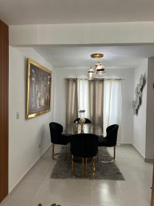 une salle à manger avec une table et des chaises en verre dans l'établissement Hermoso y amplio apartamento de 3 habitaciones y 2 baños !, à San Pedro de Macorís