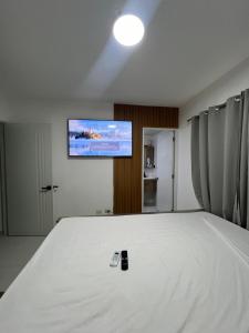 - une chambre avec un grand lit blanc et une télévision à écran plat dans l'établissement Hermoso y amplio apartamento de 3 habitaciones y 2 baños !, à San Pedro de Macorís