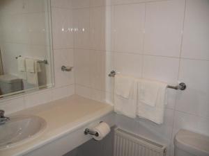 a bathroom with a toilet, sink and tub at Skylark Hotel in Southend-on-Sea