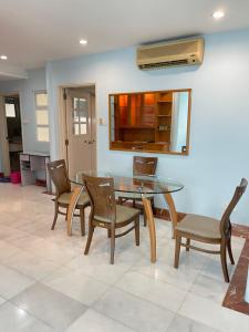 a dining room with a glass table and chairs at Hock Lee Hotel Residences - Anna 温馨公寓式的住宅 in Kuching