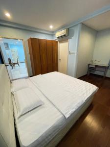 a bedroom with a large bed with white sheets at Hock Lee Hotel Residences - Anna 温馨公寓式的住宅 in Kuching