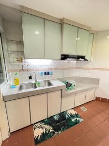 a kitchen with white cabinets and a sink at Hock Lee Hotel Residences - Anna 温馨公寓式的住宅 in Kuching