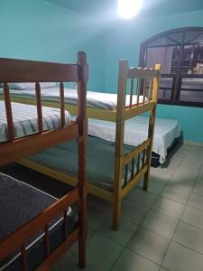 a bedroom with two bunk beds and a chair at Casa de Praia aconchego in Guaratuba
