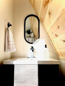 a bathroom with a sink and a mirror at The Charlotte A-Frame cabin with mountain views in Wilsonville