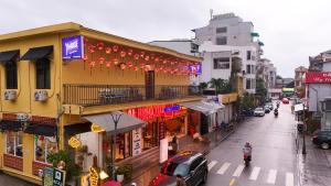 a busy city street with buildings and cars on the road at Yo'House Hue Homestay in Hue