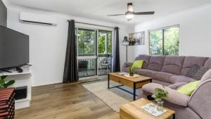 a living room with a couch and a tv at Family Holiday Perfection in Bellara