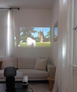 a living room with a couch and a tv on the wall at Appartement et jardin près du lac in Nidau