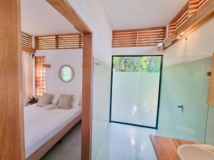 a bedroom with a bed and a glass door at Ananá Garden Studio AC 5 Min to Playa Chiquita in Puerto Viejo