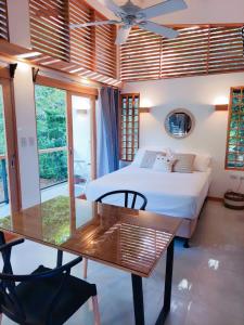 a bedroom with a bed and a glass table at Ananá Garden Studio AC 5 Min to Playa Chiquita in Puerto Viejo