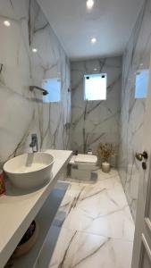 Un baño blanco con lavabo y espejo. en Casa em condomínio Recreio com Portaria, en Río de Janeiro