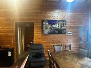 a dining room with a table and a television on a wall at Cabañas quilquico spa in Quilquico