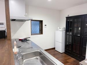 a kitchen with a sink and a white refrigerator at 風花Fuka民泊大森西002 in Tokyo