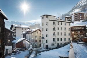 a view of a building in the snow at Le Petit CHARME-INN in Zermatt