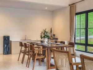 a dining room with a wooden table and chairs at Arunika Villa in Ciloto