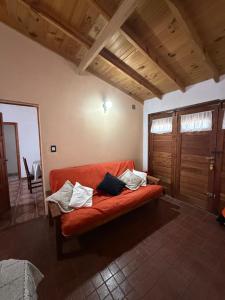 an orange couch in a living room with wooden ceilings at Casa Mar de Cobo in Mar de Cobo